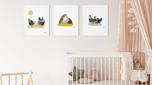Three chicken posters in white frames on a wall in a nursery with light peach color theme