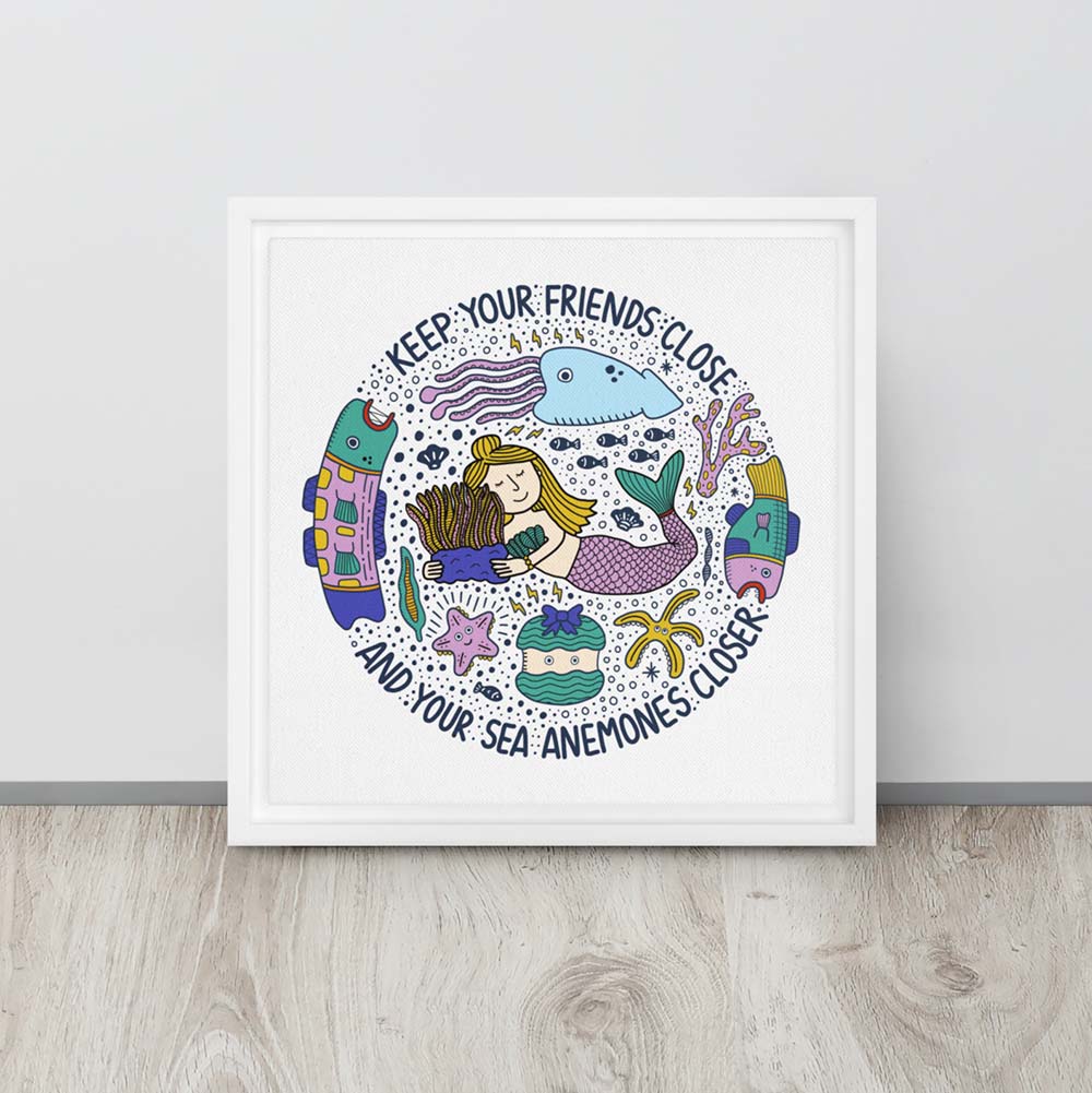 Mermaid hugging sea anemone surrounded by colorful ocean creatures with the phrase “Keep your friends close and your sea anemones closer” – framed square canvas wall art in white floating frame leaning against a wall