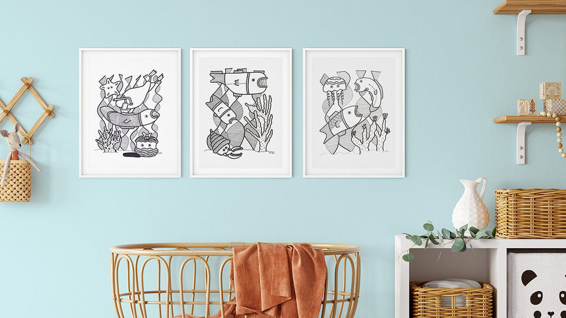 Three framed nursery wall art prints featuring whimsical sea creatures, displayed above a cozy crib in a baby nursery with soft, neutral decor